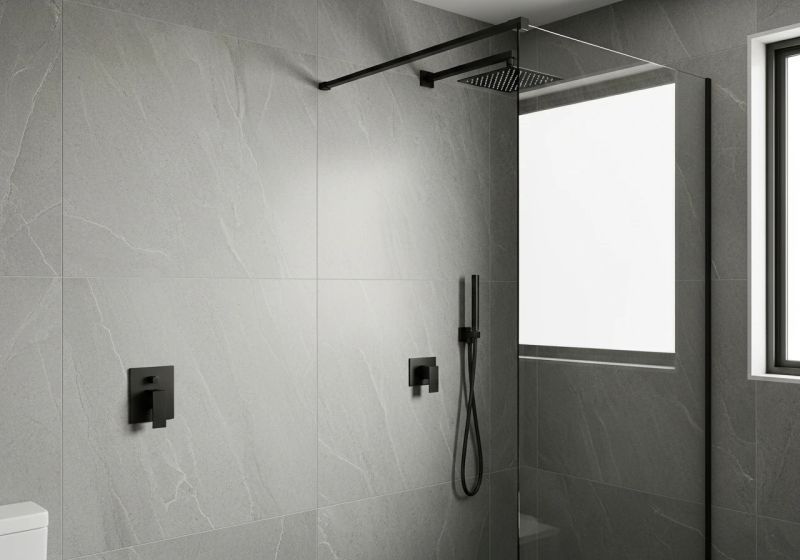 Modern bathroom renovation Hills District — grey stone tiles, frameless glass shower, matte black fittings