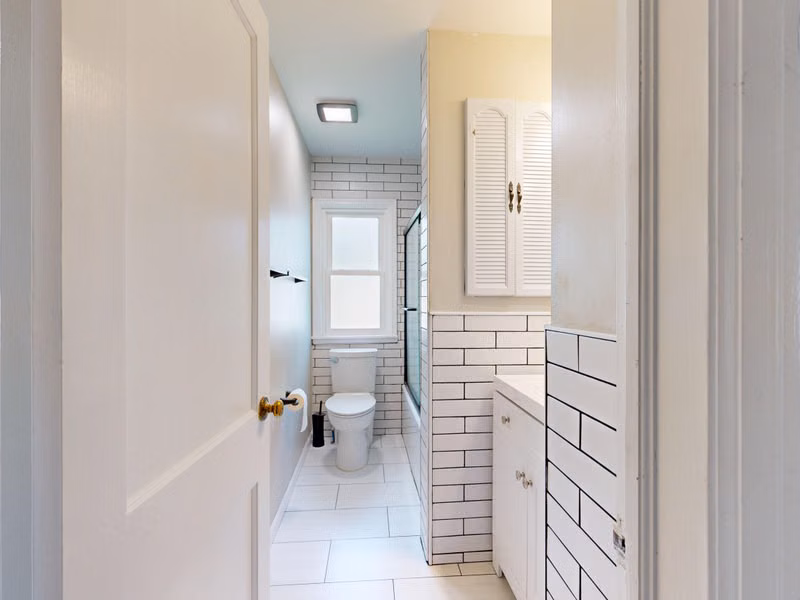 Bright modern white bathroom featuring subway tiles and minimalist design.