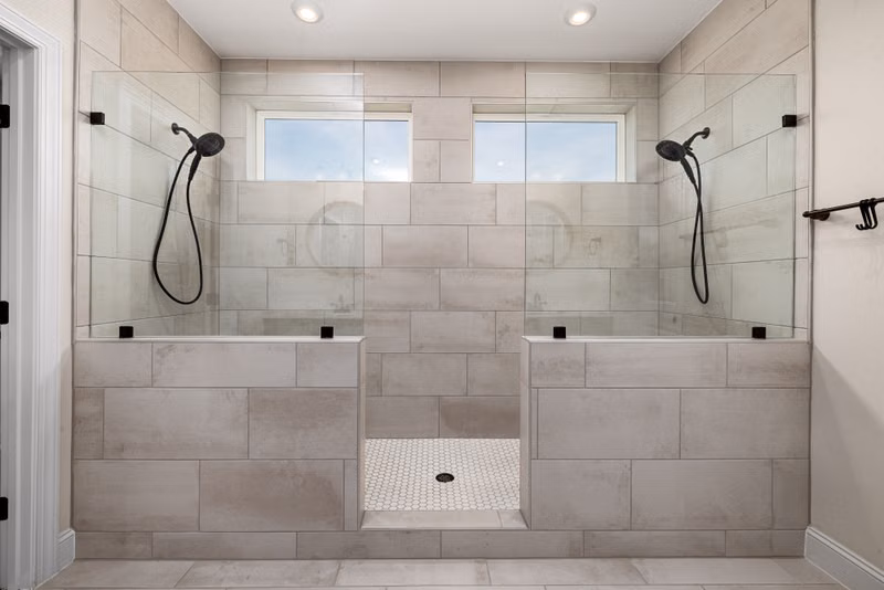 A sleek, contemporary dual shower bathroom featuring elegant tile work and modern fixtures.